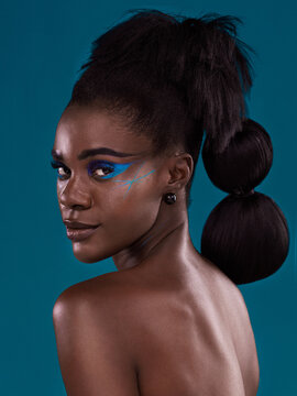 Beauty Gone Avant Garde. Studio Portrait Of A Beautiful Young Woman Posing Against A Turquoise Background.