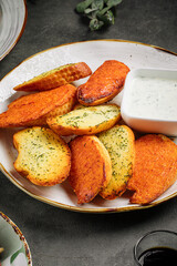 Closeup on garlic bread appetizer plate with sour cream sauce
