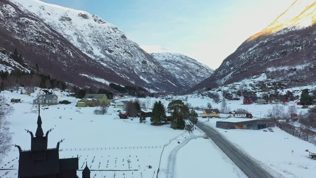 Borgund valley close to Laerdal Norway - Upward moving aerial close to stave churc revealing panoramic view during winter sunset