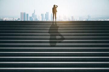 Back view of businesswoman on top of concrete stairs looking into the distance on daylight city background. Success and future concept.