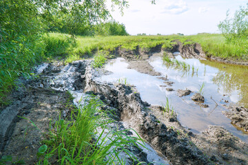 A country road in mud, slush and water after rain. Mud on the forest road