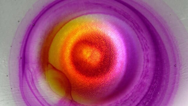 Neon orange purple inks splash. Explosion circle with the center. Decorative liquid abstract background. Chemical reaction. The Universe Cosmos Eye of God Nebula