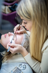 Eyelash extension procedure in beauty salon. Lashes close up. Concept spa lash. 