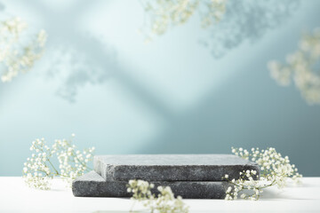 Flat granite pedestal and white flowers on blue background.  Showcase for cosmetic products. Product advertisement. Layout style design. - obrazy, fototapety, plakaty