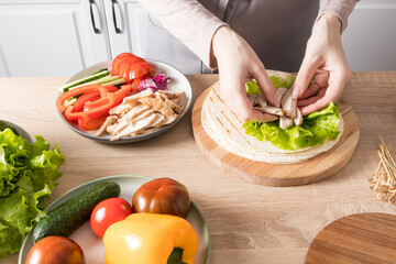 cooking homemade tortillas with chicken and fresh vegetables on the kitchen table at home. delicious healthy lunch, snack.