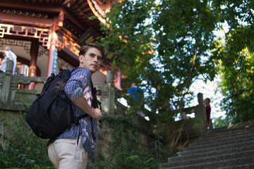 Young tourist traveler with backpack ready for autumn adventure in Asia.