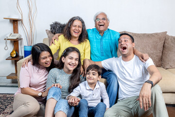 Fototapeta premium family sitting on sofa and smiling