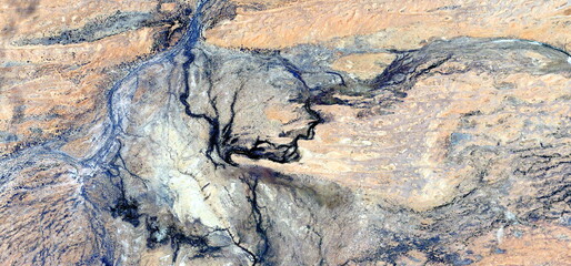 abstract landscape of the deserts of Africa from the air emulating the shapes and colors of the river that overflows, Genre: Abstract a fossil worm, from the abstract to the figurative