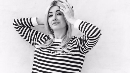  60s-70s look. Woman blonde hair vintage makeup wear striped jumper, fashionable concept