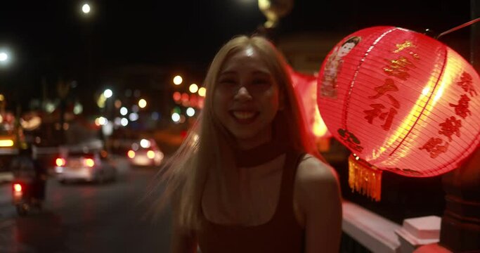 Slow motion Young Asian girl running on street among Chinese lantern in Chinese new year lantern festival. Night street travel.