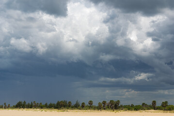 Fototapeta na wymiar Storm clouds over a flat tropical landscape
