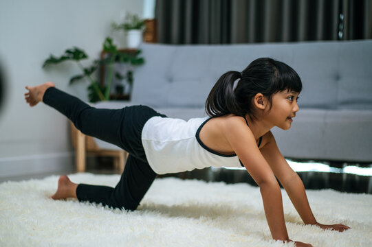 girl doing yoga in room on white carpet
