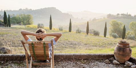 Young man looking at the valley in Tuscany, Italy, relaxation, vacations, lifestyle, summer fun,...