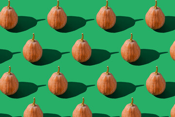 Pattern of pumpkins on green background. Autumn harvest. Pumpkin. Thanksgiving Day. Food for Halloween.