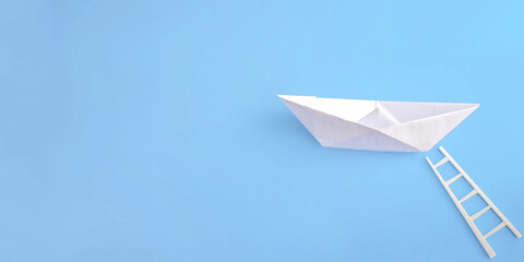 White paper boat with a white ladder on a blue background