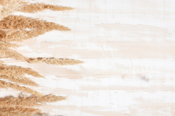 Old rustic wood table with dry flowers top view, copy space. Background in boho style with pampas grass.