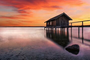 Obraz premium Traditional boathouse at lake Ammersee near Munich, Bavaria, Germany at sunrise.