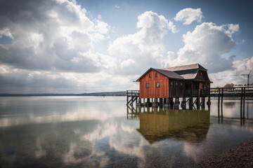 Traditional boathouse at lake Ammersee near Munich, Bavaria, Germany at sunrise. - obrazy, fototapety, plakaty