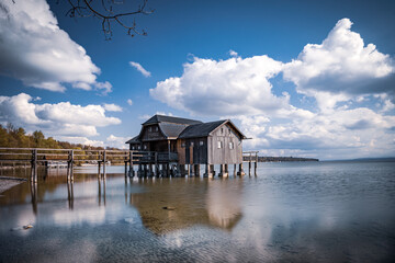 Traditional boathouse at lake Ammersee near Munich, Bavaria, Germany at sunrise.