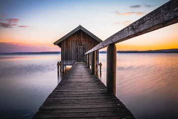 Traditional boathouse at lake Ammersee near Munich, Bavaria, Germany at sunrise.