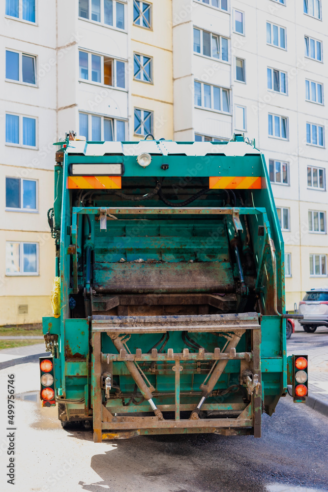 Poster an automobile garbage truck collects garbage in residential areas of a modern city. close-up of a ca