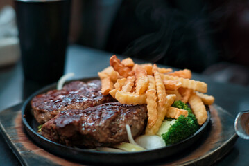 Delicious teppanyaki steak and fries with smoke