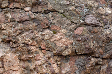 The texture of cracked rock consisting of small stones. Horizontal.