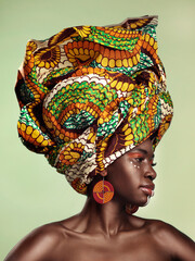 Life is better in colour. Studio shot of a beautiful young woman wearing a traditional African head wrap against a green background. - obrazy, fototapety, plakaty