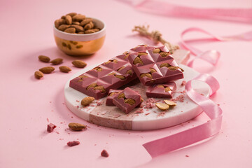 ruby chocolate and almonds on pink background