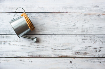 Metal silvery watering can on a white wooden background. The concept of ecology, farming, gardening