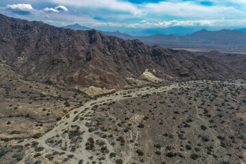 arid mountains in them you can see power towers and highways.