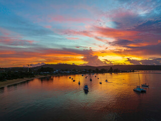 Obraz premium Aerial sunrise waterscape with boats, colour and clouds