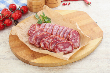 Sliced salami sausages over board