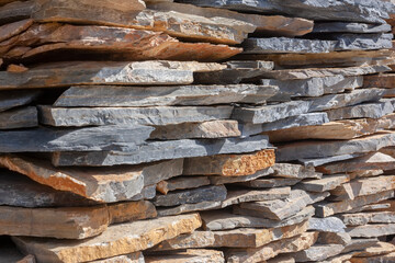 Slabs of natural stone stacked in layers. Folded flagstone.