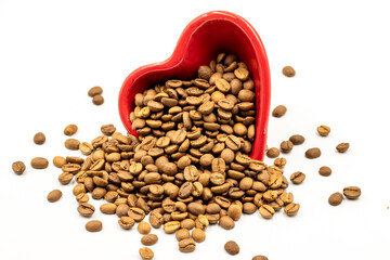 Coffee beans isolated on a white background. Full of coffee beans in a heart shaped plate. Close-up.