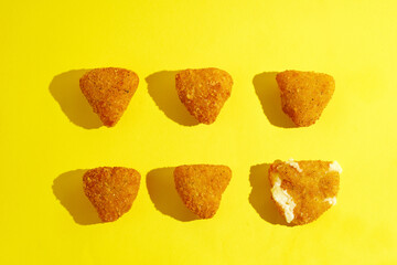 Pattern of deep-fried camembert on yellow background