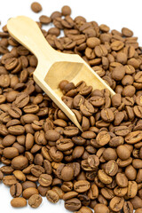 Coffee beans isolated on a white background. Full of coffee beans in a wooden spoon. Close-up.