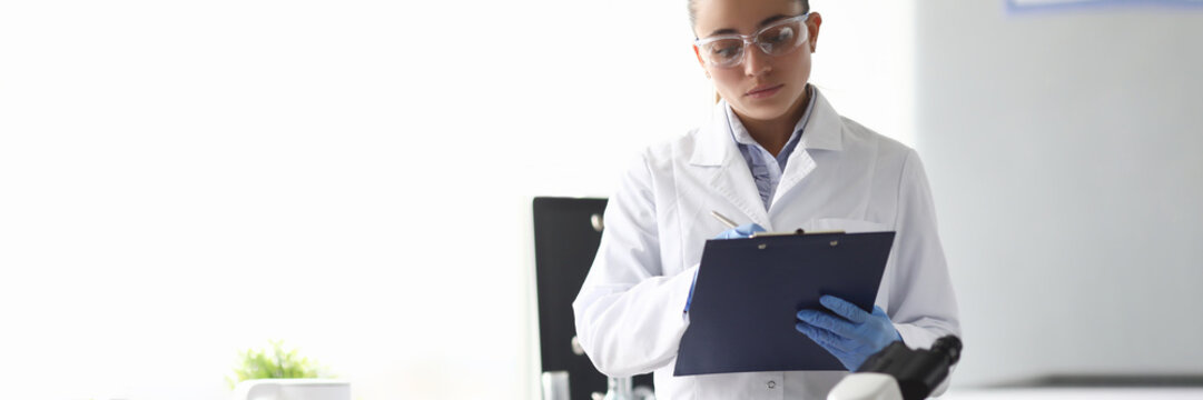 Woman Scientist Chemist Writing In Documents In Chemical Laboratory