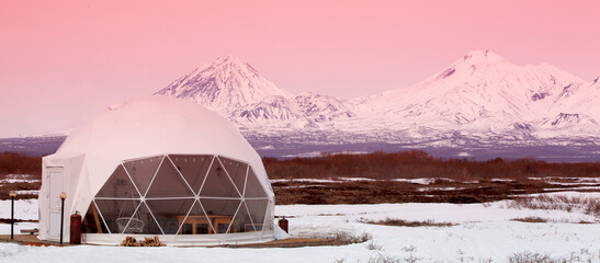 Glamping house and volcano, rural landscape, tent houses in Kamchatka peninsula. Selective focus.
