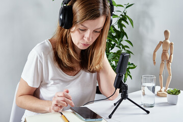 Woman listening online course in headphones, distance education. Freelancer sitting at workplace...