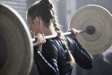 Dont just think about it, do it. Shot of an athletic young woman working out with a barbell at the gym.