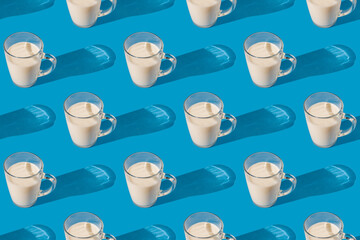 Glass mug of fresh milk on a blue background. Repeating seamless pattern
