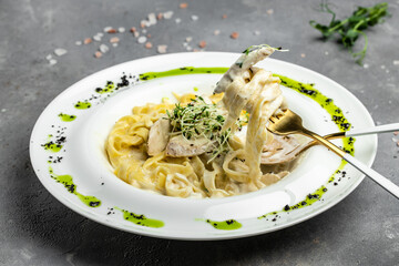 Fettuccine alfredo in a creamy sauce with chicken, parmesan on white plate. Pasta alfredo with chicken. Italian cuisine. banner, menu, recipe place for text, top view