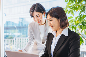 相談して働く2人の女性（ビジネスイメージ）