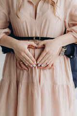 couple holding hands on pregnant belly