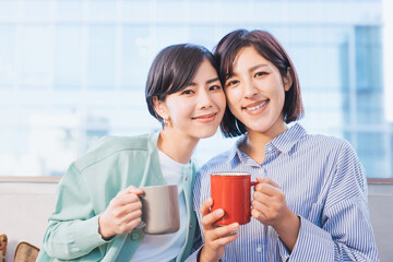 カップを手にする2人の女性（女性同士のパートナーのイメージ）