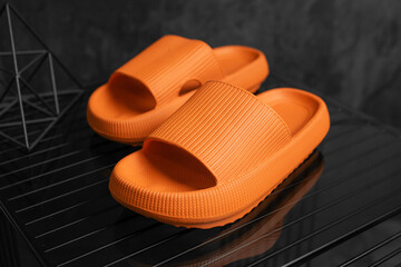 Colorful orange Sandals shoes. Orange flip flops on dark black background.