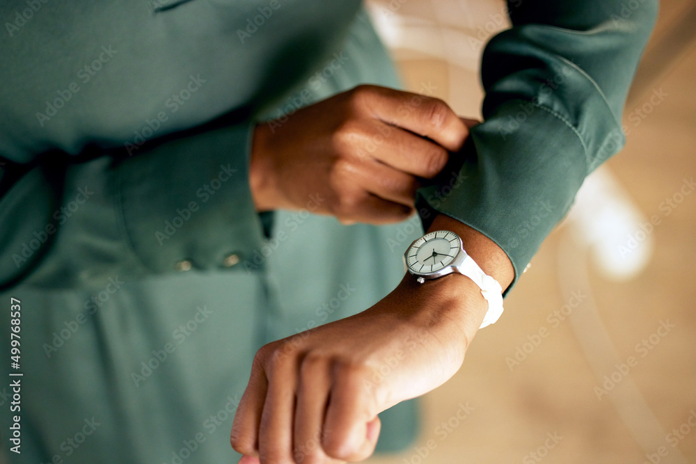 Poster looks like its time for business. shot of an unrecognizable businessperson checking the time at work