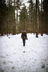 A lone photographer on a hike in a snowy winter forest