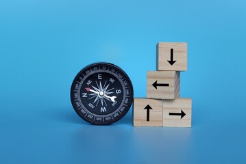Compass and wooden cubes with arrow on blue background. Looking for direction, guidance concept